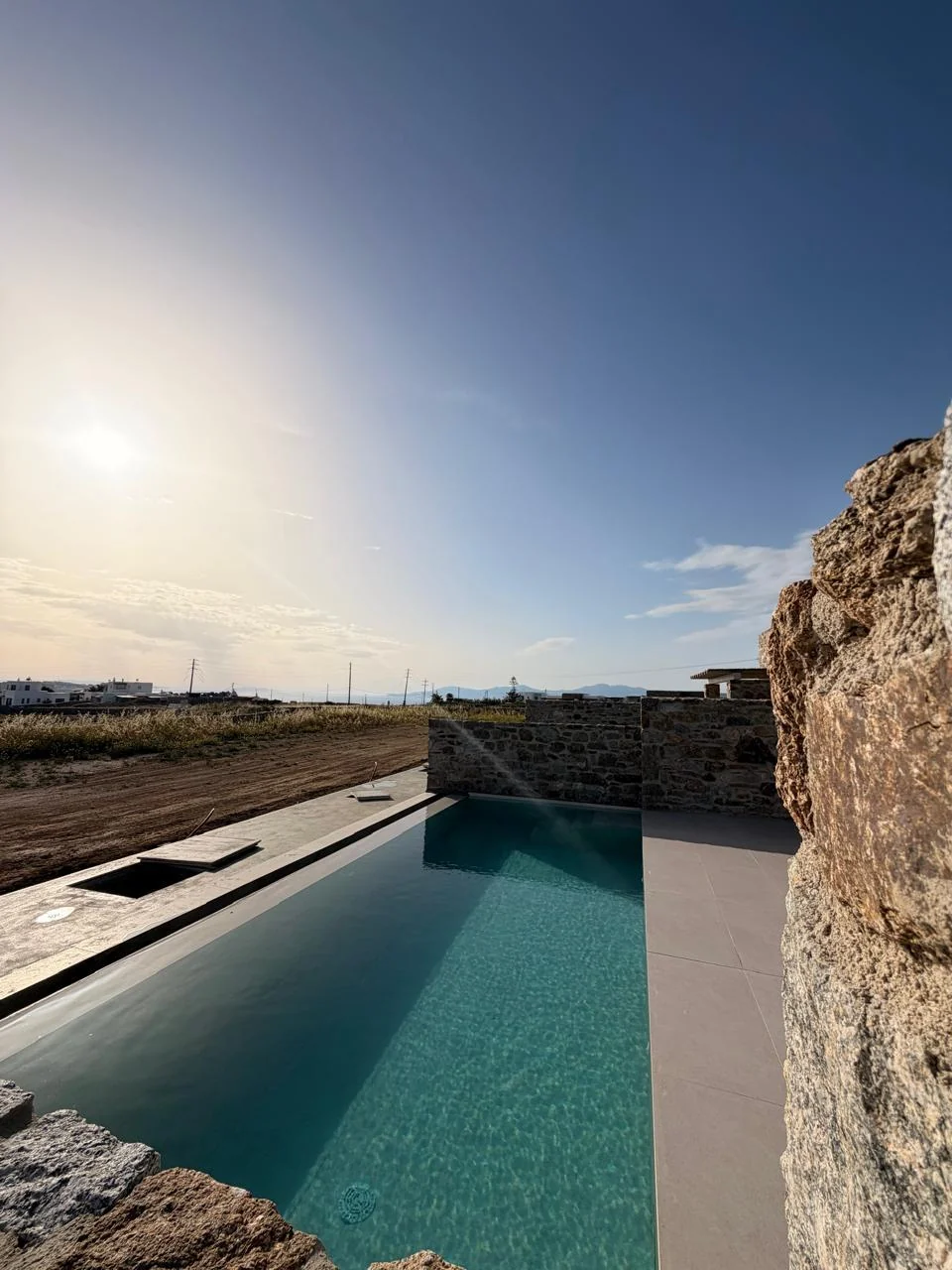 Paragka, Mykonos · Outdoor pool beside a stone residence.