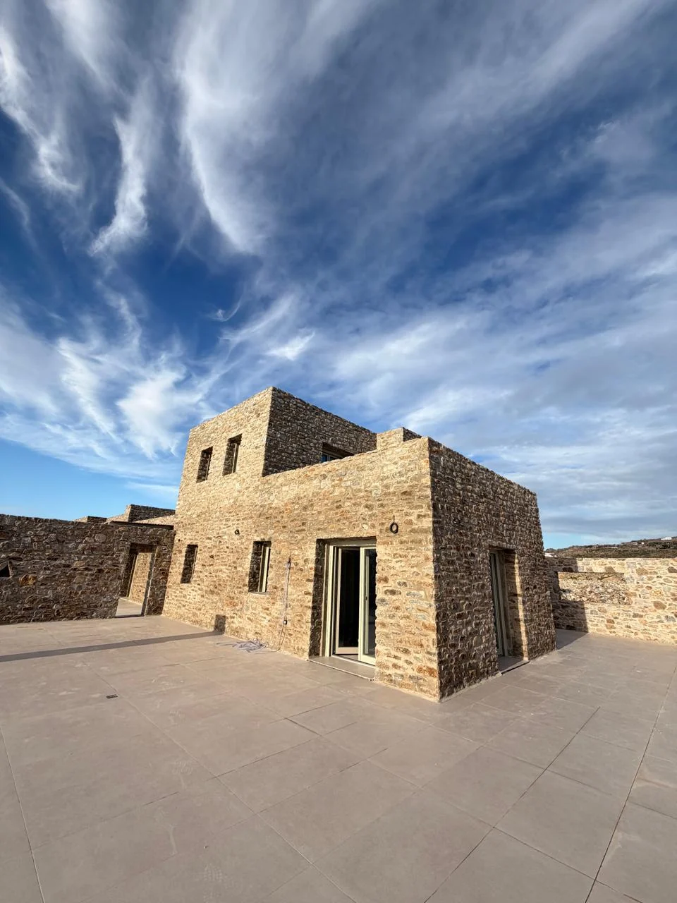 Paragka, Mykonos · Two-storey stone volume and adjoining terrace.