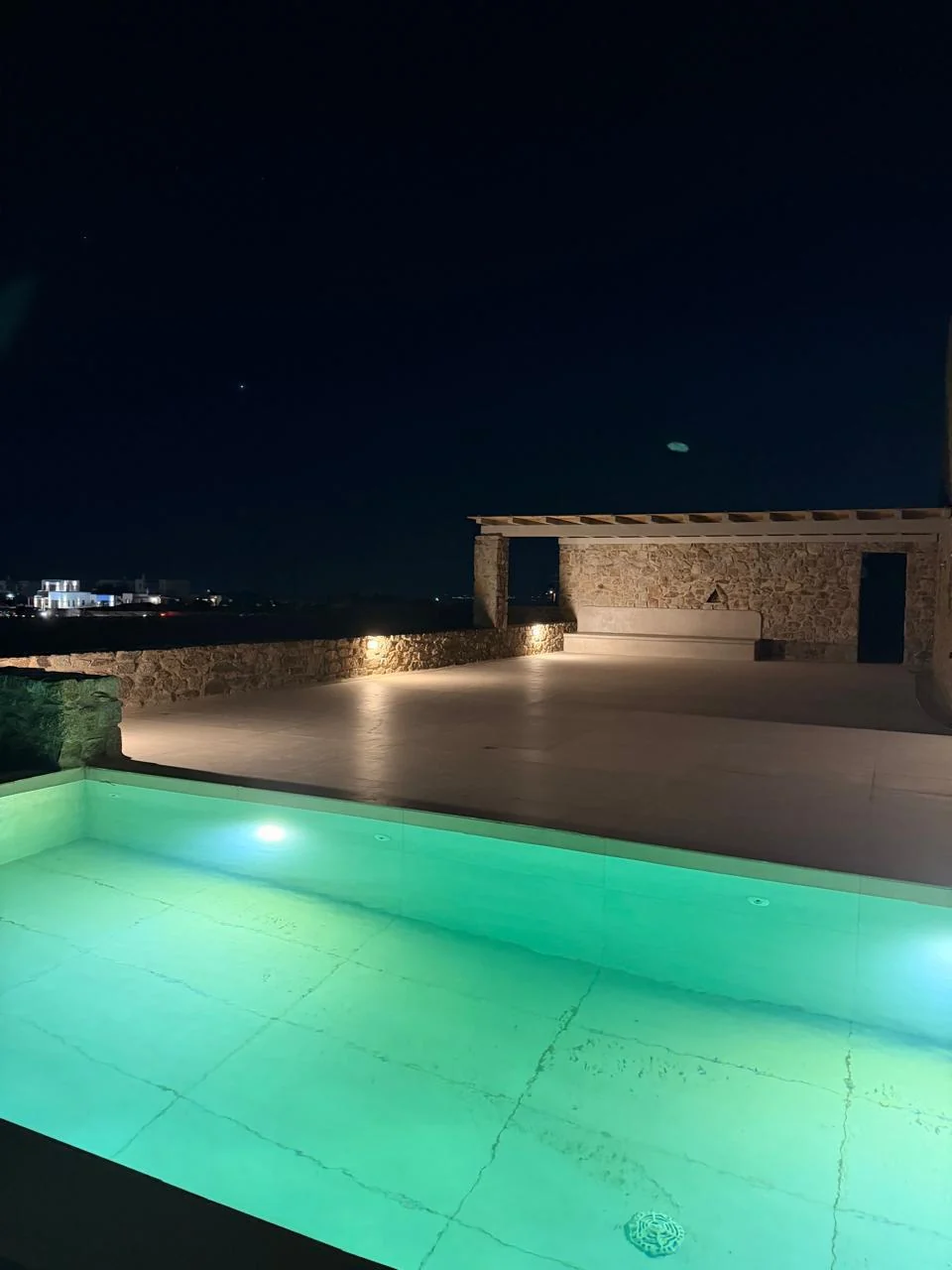 Paragka, Mykonos · Illuminated outdoor pool and terrace at night.