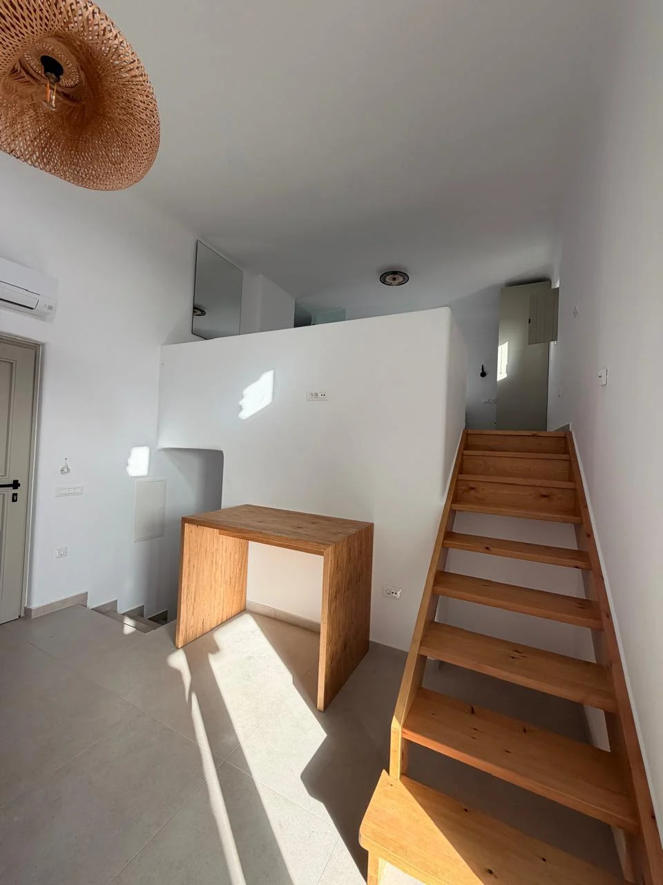 Paragka, Mykonos · Interior stair and living space with timber details.