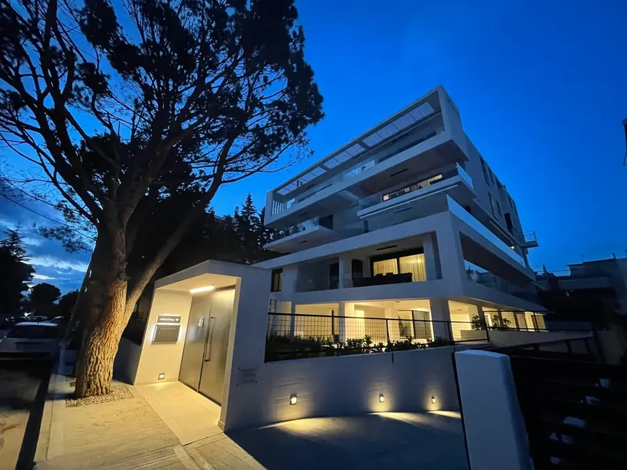 Λευκό κτίριο διαμερισμάτων φωτισμένο το σούρουπο
