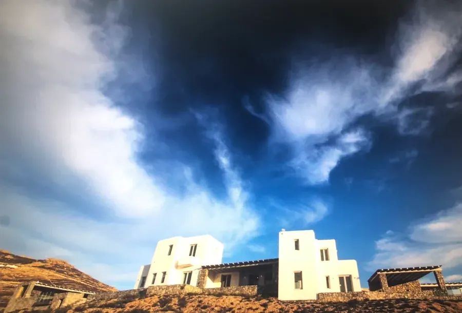 Λευκά νησιωτικά κτίρια κάτω από έντονα συννεφιασμένο ουρανό
