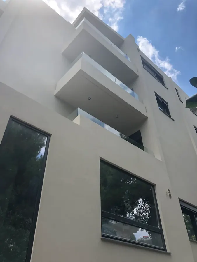 Γωνία λευκής κατοικίας με ψηλό σκούρο σκίαστρο