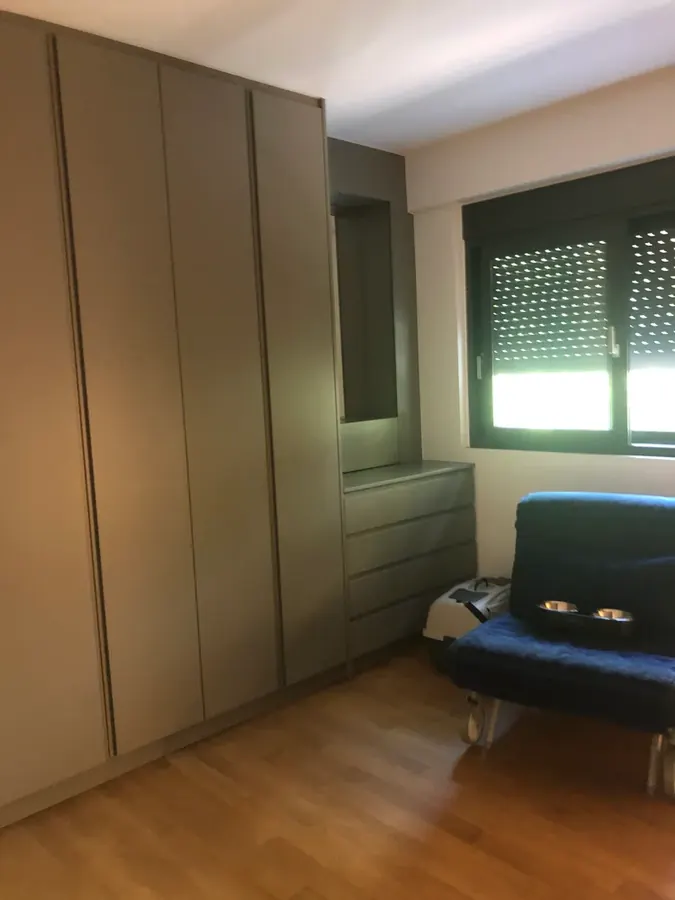 Εντοιχισμένες ντουλάπες δίπλα σε παράθυρο με ρολό